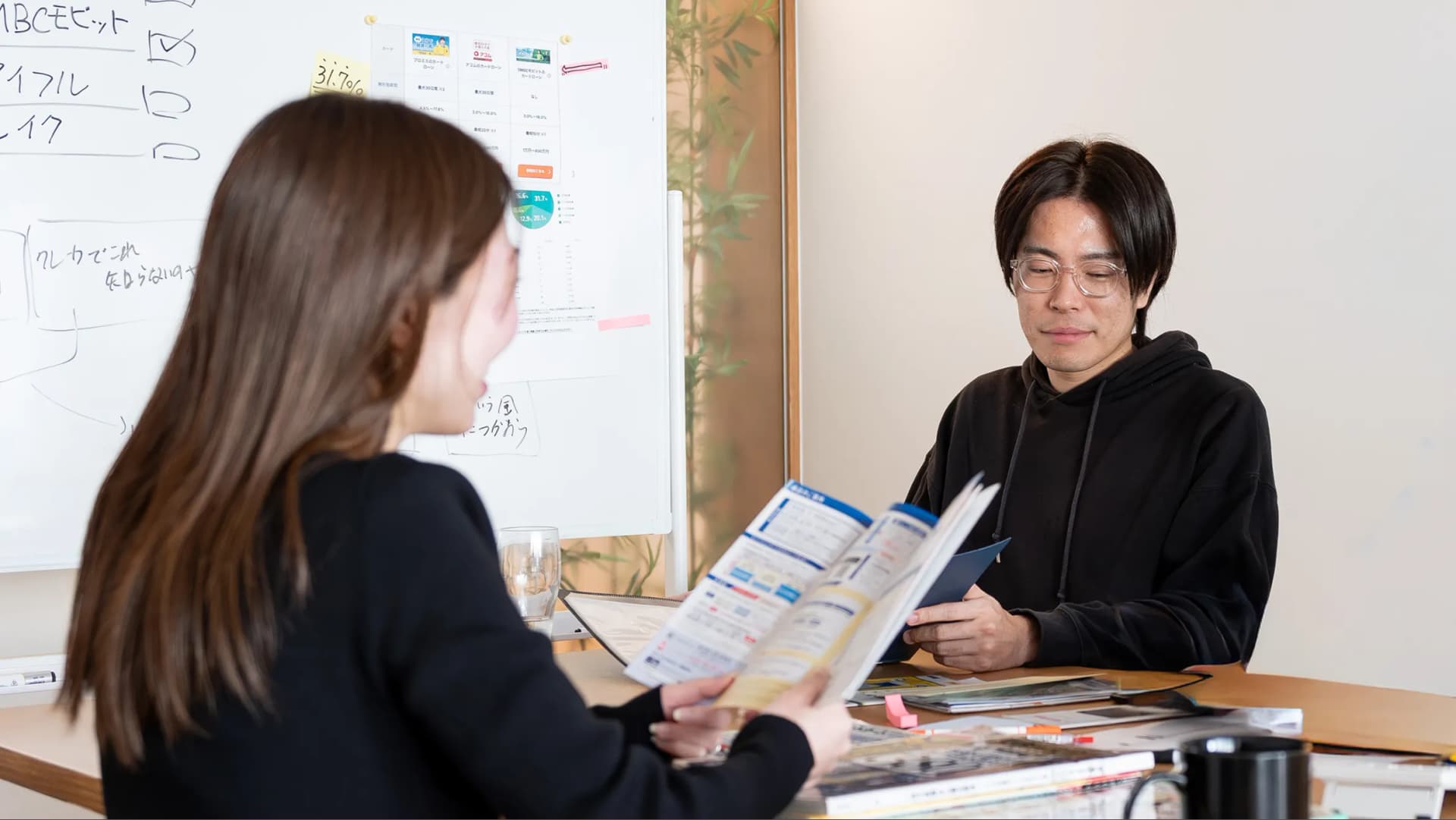 写真。製作陣がクレジットカードを並べて資料とともに検証している様子