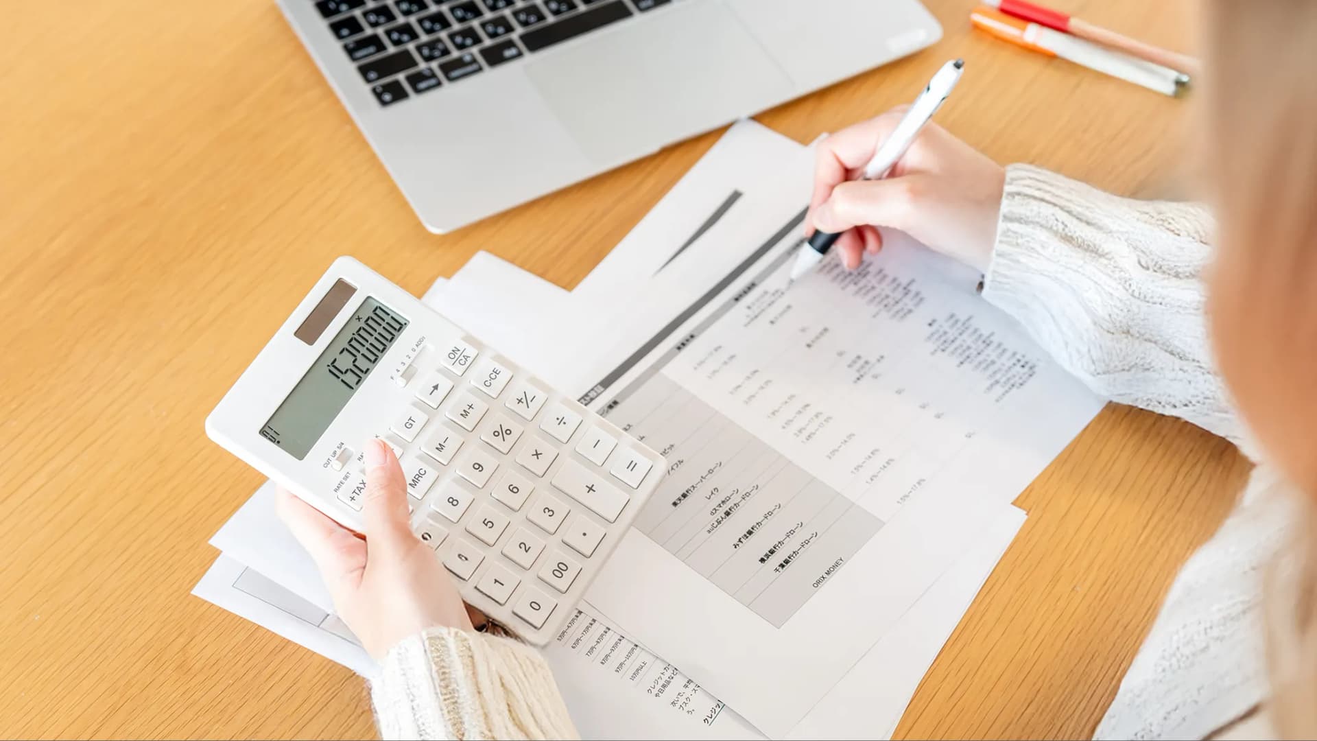 写真。紙に書かれた評価項目をもとに電卓を使って計算している様子