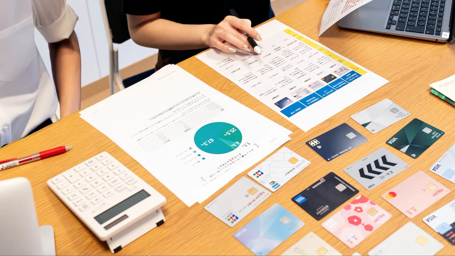 写真。製作陣がクレジットカードを並べて資料とともに検証している様子